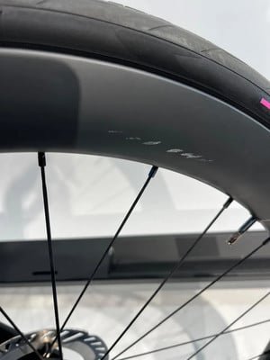 Nahaufnahme eines Fahrradrads mit kleinen Kratzern auf der Felge.