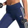 Eine Frau in dunkelblauen Leggings mit beige Streifen und Adidas-Logo hält Hanteln.