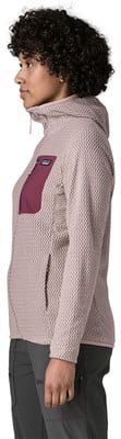 Frau in einem rosa Fleece-Pullover mit Kapuze und Brusttasche.