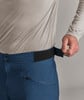 Ein Mann schließt den Klettverschluss an einer marineblauen Hose um die Taille.