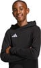 Ein Junge in einem schwarzen Hoodie mit Adidas-Logo lächelt.