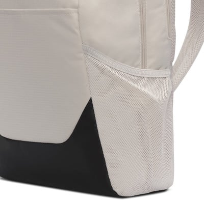 Nahaufnahme eines Rucksacks mit beigem Stoff, schwarzem Teil und Netztasche. Nahaufnahme eines Rucksacks mit beigem Stoff, schwarzem Teil und Netztasche.