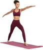 Eine Frau in weinroter Sportkleidung macht Yoga auf einer Matte.