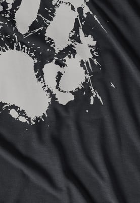 Detail eines dunklen Stoffes mit einem weißen Pfotenabdruck-ähnlichen Druck.