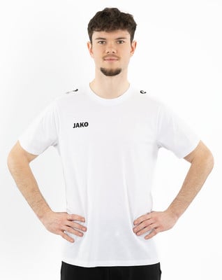Ein Mann in einem weißen JAKO T-Shirt und schwarzer Hose steht. Ein Mann in einem weißen JAKO T-Shirt und schwarzer Hose steht.