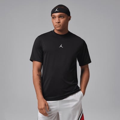 Ein Mann in einem schwarzen T-Shirt und weißen Shorts mit Aufdruck und Jordan-Logo. Ein Mann in einem schwarzen T-Shirt und weißen Shorts mit Aufdruck und Jordan-Logo.