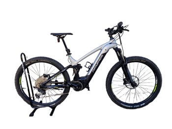 Ein silbernes E-Bike auf einem Ständer vor weißem Hintergrund.