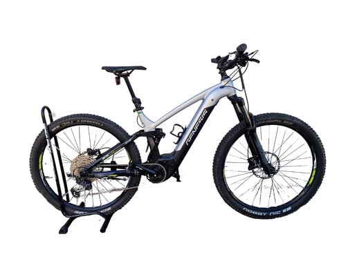 Ein silbernes E-Bike auf einem Ständer vor weißem Hintergrund.