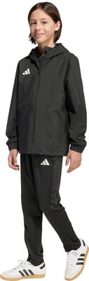 Junge in schwarzer Adidas-Sportkleidung mit weißem Logo. Junge in schwarzer Adidas-Sportkleidung mit weißem Logo.