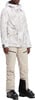 Damen-Skijacke mit Print und beige Skihose mit Skischuhen.