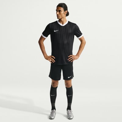 Ein Mann in einem schwarzen Fußballtrikot und Shorts mit weißen Details. Ein Mann in einem schwarzen Fußballtrikot und Shorts mit weißen Details.