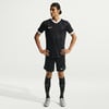 Ein Mann in einem schwarzen Fußballtrikot und Shorts mit weißen Details.