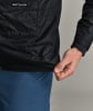 Schwarze gesteppte Jacke mit Ortovox-Logo und blauer Hose.