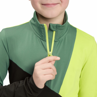 Ein Kind schließt eine grüne Jacke mit einem gelben Reißverschluss. Ein Kind schließt eine grüne Jacke mit einem gelben Reißverschluss.