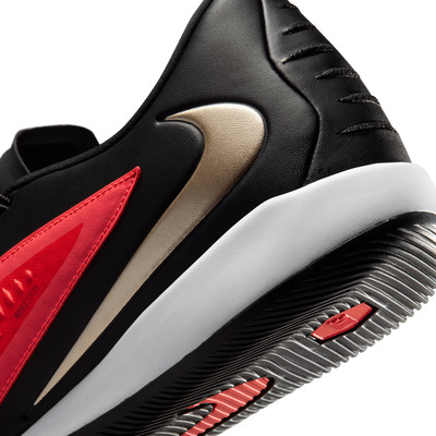 Detail eines schwarzen Nike-Sportschuhs mit goldenem und rotem Logo.