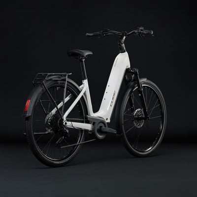Ein weißes Cube E-Bike mit Gepäckträger und Schutzblechen vor dunklem Hintergrund. Ein weißes Cube E-Bike mit Gepäckträger und Schutzblechen vor dunklem Hintergrund.