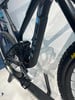 Schwarzes Mountainbike mit Dämpfer und Pedalen auf einem Ständer.