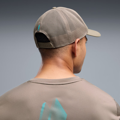 Rückansicht eines Mannes mit Puma-Kappe und T-Shirt mit Bergmotiv. Rückansicht eines Mannes mit Puma-Kappe und T-Shirt mit Bergmotiv.
