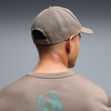 Rückansicht eines Mannes mit Puma-Kappe und T-Shirt mit Bergmotiv.