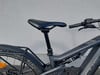 Detail von Sattel und Lenker eines E-Bikes mit Dämpfer und Gepäckträger.
