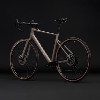 Ein braunes Cube Gravelbike mit schwarzen Felgen und braunen Reifen vor dunklem Hintergrund. Ein braunes Cube Gravelbike mit schwarzen Felgen und braunen Reifen vor dunklem Hintergrund.