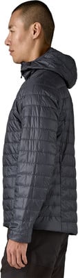 Ein Mann im Profil trägt eine dunkle Steppjacke mit Kapuze.