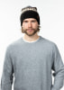 Mann mit gestrickter Mütze im norwegischen Muster und grauem Pullover.