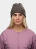 Junge Frau mit blonden Haaren trägt eine braune Mütze und eine rosa Jacke.
