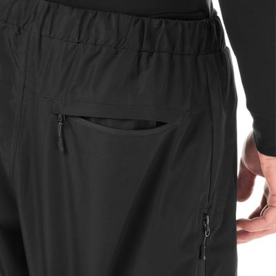 Detail einer schwarzen Hose mit Reißverschlusstasche und elastischem Bund.