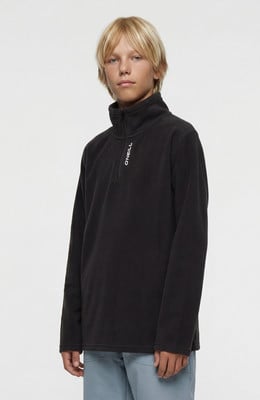 Junge in schwarzem Fleece-Pullover mit O'Neill-Logo und hellblauer Hose. Junge in schwarzem Fleece-Pullover mit O'Neill-Logo und hellblauer Hose.