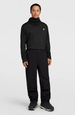 Ein Mann im schwarzen Rollkragenpullover und Hose steht vor weißem Hintergrund. Ein Mann im schwarzen Rollkragenpullover und Hose steht vor weißem Hintergrund.