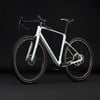 Modernes hellblaues Gravelbike vor schwarzem Hintergrund.