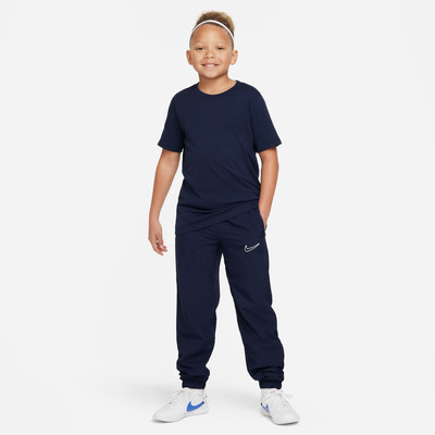 Junge in dunkelblauem T-Shirt und Jogginghose mit Nike-Logo. Junge in dunkelblauem T-Shirt und Jogginghose mit Nike-Logo.