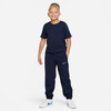 Junge in dunkelblauem T-Shirt und Jogginghose mit Nike-Logo.