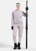 Eine Frau mit Skiern, gekleidet in einem rosa Skianzug und schwarzen Handschuhen.