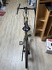 Ein Mountainbike mit schwarzem Sattel und Lenker auf Holzboden.
