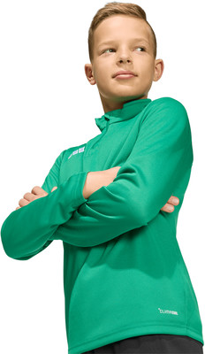 Ein Junge in einem grünen Langarmshirt hat die Arme verschränkt. Ein Junge in einem grünen Langarmshirt hat die Arme verschränkt.