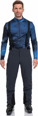 Ein Mann in stilvoller Skibekleidung mit blauem Oberteil und dunkler Hose. Ein Mann in stilvoller Skibekleidung mit blauem Oberteil und dunkler Hose.