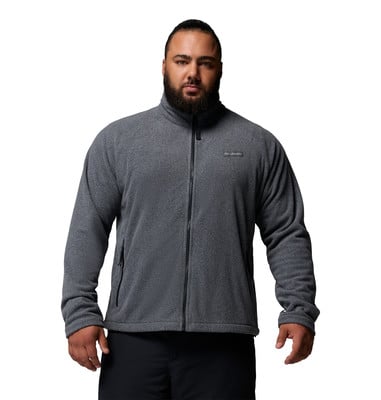 Ein Mann in einem dunkelgrauen Fleece-Reißverschluss und schwarzer Hose.
