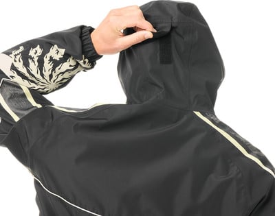 Rückansicht einer schwarzen Kapuzenjacke mit beigem Muster am Ärmel. Rückansicht einer schwarzen Kapuzenjacke mit beigem Muster am Ärmel.