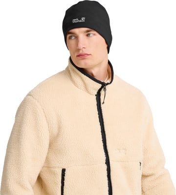 Mann in schwarzer Mütze und beige Fleecejacke mit Jack Wolfskin Logo. Mann in schwarzer Mütze und beige Fleecejacke mit Jack Wolfskin Logo.