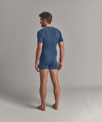 Ein Mann in einem blauen T-Shirt und Shorts steht mit dem Rücken zum Betrachter. Ein Mann in einem blauen T-Shirt und Shorts steht mit dem Rücken zum Betrachter.