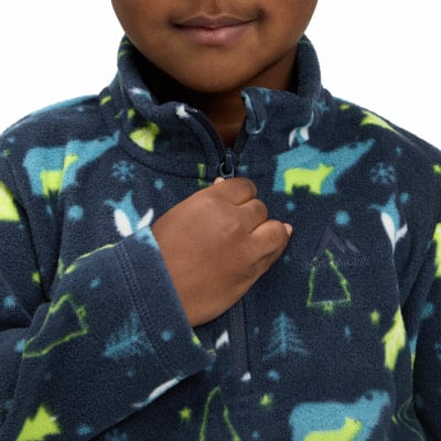 Ein Kind trägt einen dunkelblauen Fleece-Pullover mit Bären- und Schneeflockenmuster. Ein Kind trägt einen dunkelblauen Fleece-Pullover mit Bären- und Schneeflockenmuster.