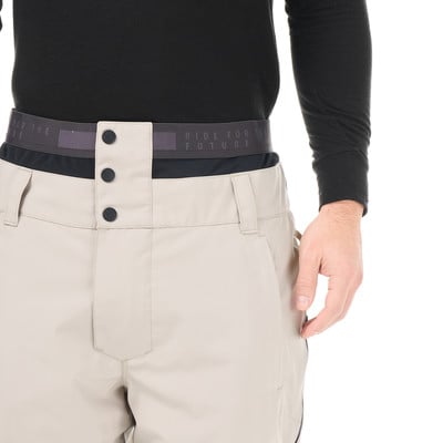 Detail einer beigen Skihose für Herren mit Logo auf dem Bund. Detail einer beigen Skihose für Herren mit Logo auf dem Bund.