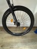 Vorderes Mountainbike-Rad mit RockShox-Federung auf Holzboden.