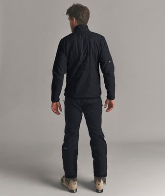 Ein Mann in schwarzer Daunenjacke und Skihose steht von hinten. Ein Mann in schwarzer Daunenjacke und Skihose steht von hinten.