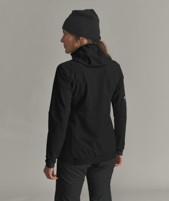 Eine Frau in einer schwarzen Jacke und Mütze posiert mit dem Rücken zur Kamera. Eine Frau in einer schwarzen Jacke und Mütze posiert mit dem Rücken zur Kamera.