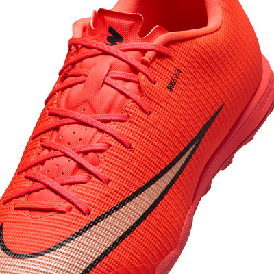 Nahaufnahme eines orangefarbenen Fußballschuhs mit Schnürsenkeln und Nike-Logo.