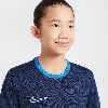 Mädchen in einem dunkelblauen T-Shirt mit Nike-Logo und blauem Kragen.