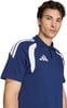 Ein Mann in einem dunkelblauen Poloshirt mit weißen Streifen an den Schultern.